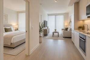 Ein modernes Apartment mit Schlafzimmer, Wohnbereich und Küchenzeile.