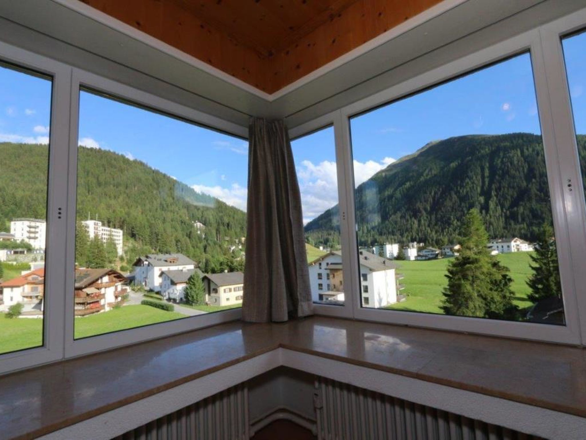 Una habitación con vistas a un paisaje montañoso a través de amplios ventanales.