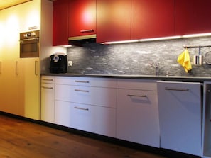 A modern kitchen with stainless steel appliances, wooden cabinets, and a black countertop backsplash. - Im Gadä Appartement/Fewo, Dusche oder Bad, WC 3-Zimmerwohnung by Interhome (Davos)