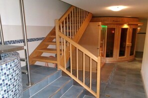 A wooden staircase with a glass enclosure leading to a room with a tiled floor. - Hinterdannerhof Schönbergblick (Jachenau)