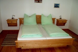 A double bed with a wooden frame and two nightstands on either side. - Hinterdannerhof Schönbergblick (Jachenau)