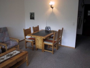 A dining area with a table and chairs, a radio, and a picture on the wall. - Palüda Sun 7 Appartement/Fewo, Dusche oder Bad, WC 1-Zimmerwohnung by Interhome (Davos)