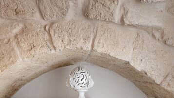 A stone wall with a white decorative object on a shelf.
