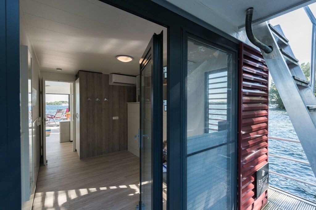Een modern interieur met een glazen deur naar een terras.