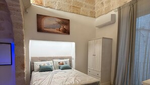 Un dormitorio con cama, armario y un cuadro en la pared.