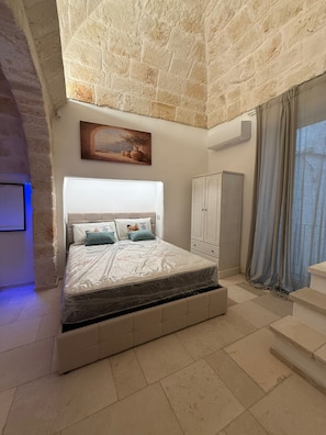 Un dormitorio con cama, armario y un cuadro en la pared.