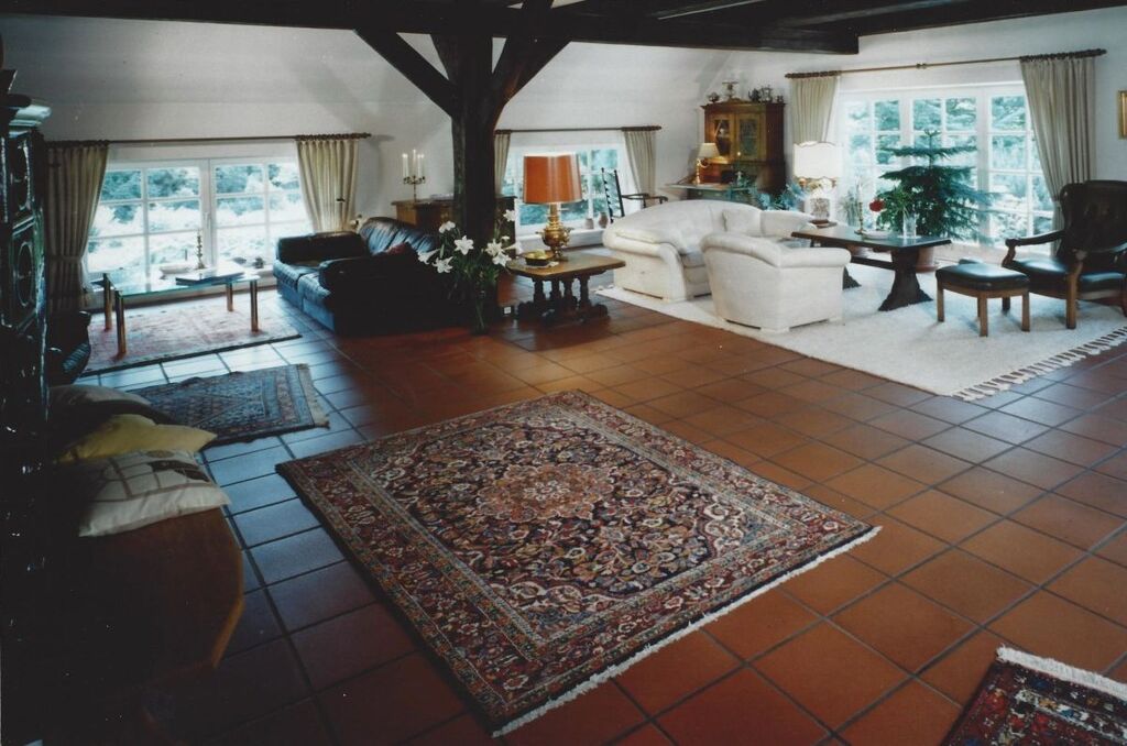 Ein geräumiges Wohnzimmer mit großem Teppich, Sofas und Kamin.