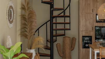 Un interior moderno con una escalera espiral, muebles de madera y una zona de cocina.