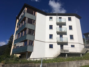 Un immeuble à plusieurs étages, doté de balcons et d’un escalier menant à un niveau supérieur.