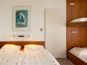A hotel room with a bed, bedside table, lamp, and a painting on the wall. - Colette 42 Appartement/Fewo, Dusche oder Bad, WC 2-Zimmerwohnung by Interhome (Davos)