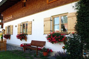 A traditional building with wooden shutters, a bench, and flower boxes. - 2 in the country house Magdalena (Oberstdorf)
