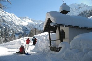A snow-covered mountain with a wooden cabin and a person skiing. - 2 in the country house Magdalena (Oberstdorf)