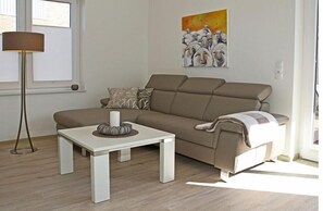 En moderne stue med en beige sofa, et hvidt sofabord og en gulvlampe.