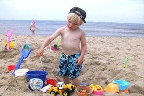 A child playing with sand toys on a beach. - Holiday home with 1 bedroom (Julianadorp aan Zee)