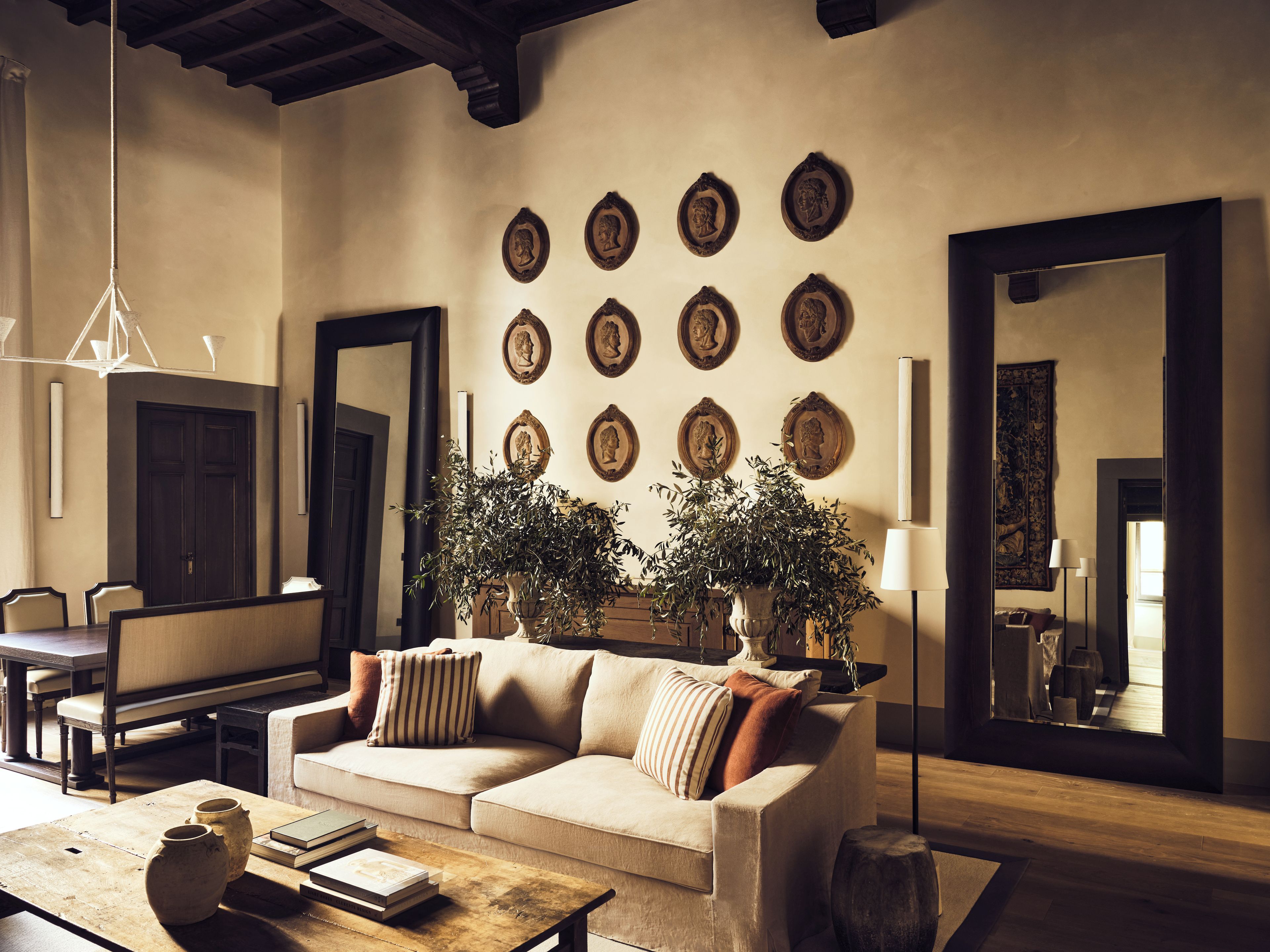 A living room with a sofa, coffee table, and decorative plates on the wall.