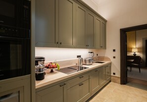 A modern kitchen with a built-in oven, a coffee maker, and a fruit bowl on the counter. - La Réserve Firenze (Firenze)