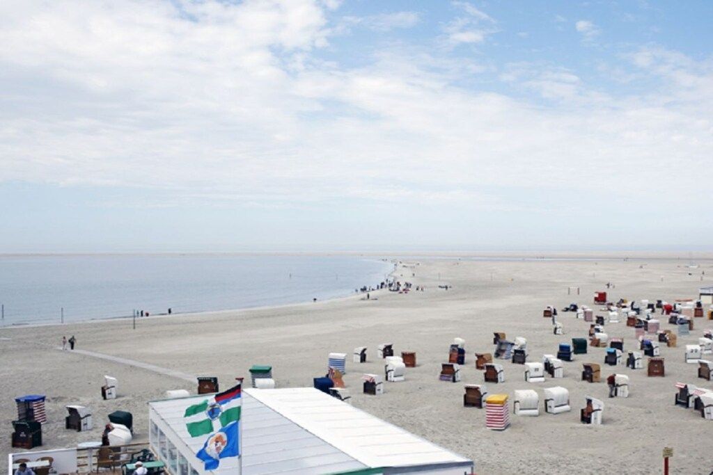 Ein Strand mit vielen Zelten und einer Flagge.