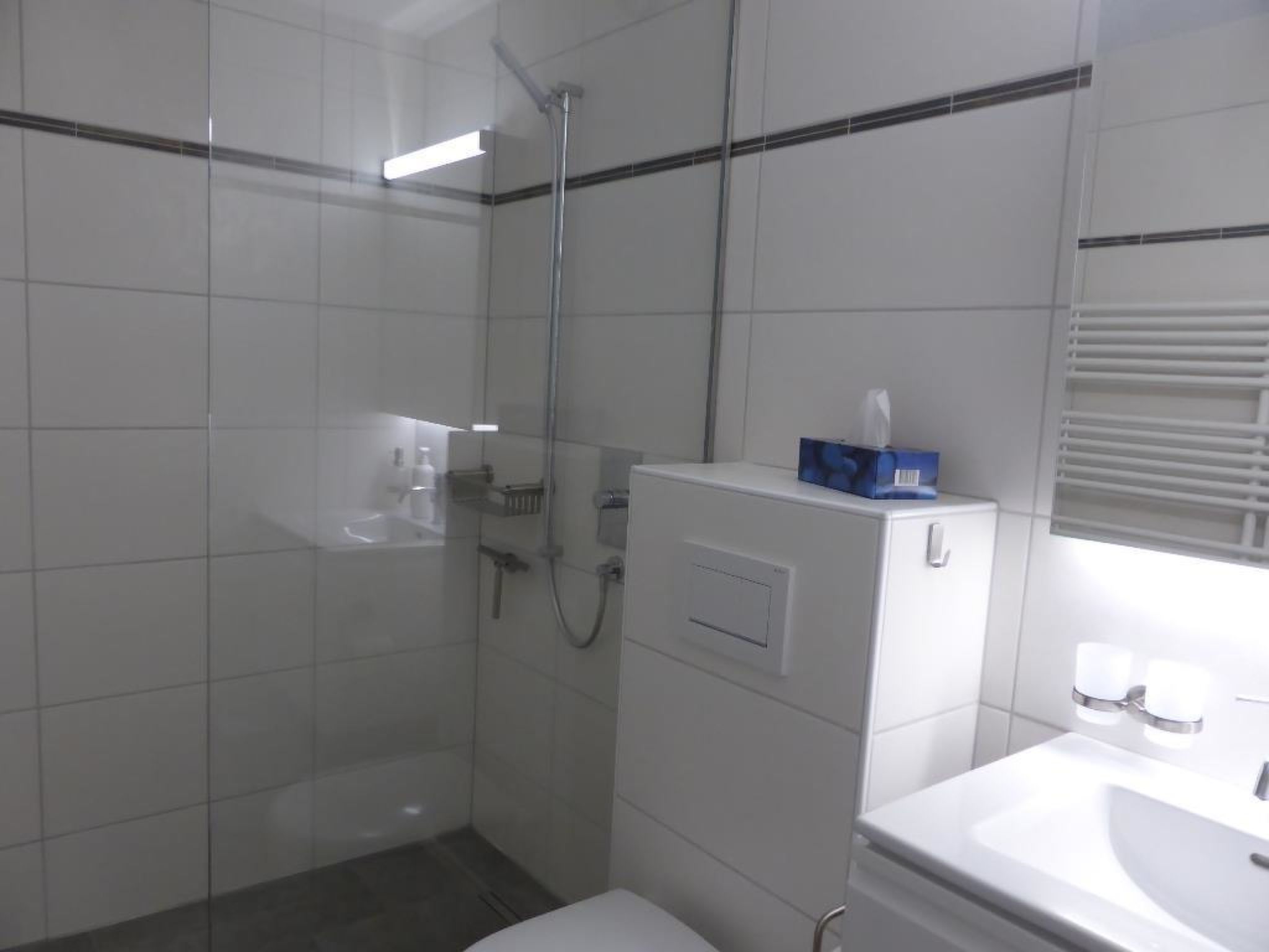 Ein Badezimmer mit Dusche, Toilette und Waschbecken.