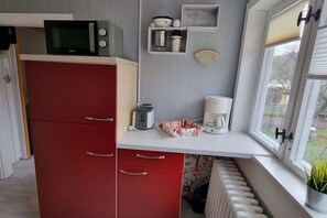 A kitchen with a microwave, toaster, and coffee maker on the counter. - Holiday home with 3 bedrooms (Blankenburg)