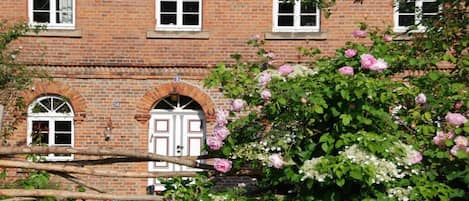 A brick building with arched windows and a white door.