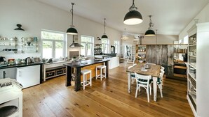 A spacious kitchen with wooden flooring, a central island, and pendant lighting. - Beautiful living at Elm (Schöppenstedt\/Eitzum)