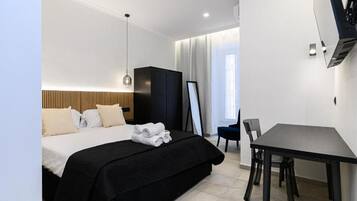 Une chambre d’hôtel avec un lit, un bureau et une chaise.