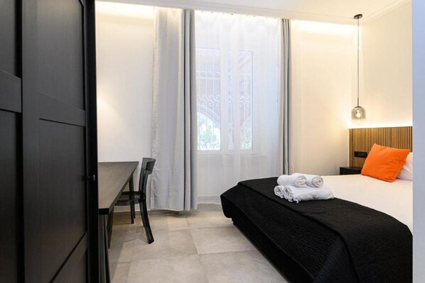 A hotel room with a bed, a desk, and a chair. - Vittorio Emanuele Arte Suites Guesthouse (Rome)