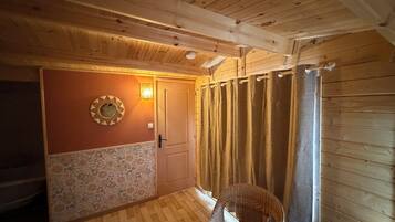 Un interior de madera con una puerta, un sillón de mimbre y una pared con diseño.