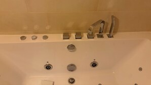 Eine Badewanne mit mehreren Wasserhähnen und einem Abfluss.