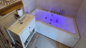Ein modernes Badezimmer mit einer freistehenden Badewanne, einem Waschtisch mit Spiegel und einer Toilette.