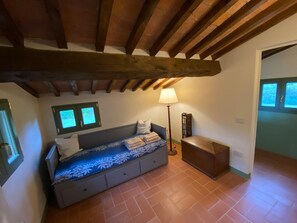 A bedroom with a bed, a bedside table, a lamp, and a window. - Villa Stalletta Hot Tub by Geco Vacation Rentals (Bolgheri)