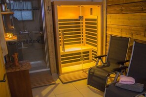 A sauna room with a wooden interior, a glass door, and a bench. - Holiday home with 1 bedroom (Neuschönau)