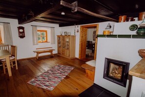 Un salon chaleureux avec une cheminée, des meubles en bois et une fenêtre agrémentée de rideaux.