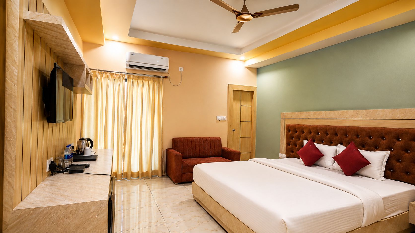 Habitación de hotel con una cama, una silla, un escritorio con hervidor y un equipo de aire acondicionado.
