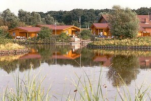 A lakeside cabin with a dock, surrounded by trees and a calm lake. - Holiday home in Vlissingen with Wi-Fi (Vlissingen)