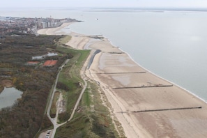 An aerial view of a coastal area with a beach, a road, and a cityscape in the background. - Holiday home in Vlissingen with Wi-Fi (Vlissingen)