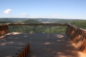 A wooden deck with a metal railing overlooking a forested valley. - Holiday apartment with 2 bedrooms (Baiersbronn-Obertal)