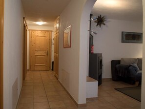 A hallway with a wooden door, a framed picture, a star-shaped light fixture, and a couch. - Heidblick Appartement/Fewo, Dusche oder Bad, WC 3½-Zimmerwohnung by Interhome (Klosters)