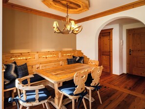 A wooden dining room with a large table and benches, a chandelier, and a wooden ceiling. - Valbella Park 102 Appartement/Fewo, Dusche oder Bad, WC 2 1/2-Zimmerwohnung by Interhome (Davos)