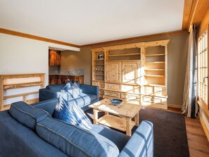 A living room with a sofa, a coffee table, and a wooden cabinet with shelves. - Valbella Park 102 Appartement/Fewo, Dusche oder Bad, WC 2 1/2-Zimmerwohnung by Interhome (Davos)