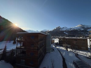 A multi-story building with a flat roof, surrounded by snow-covered ground and mountains in the background. - am Dischmabach D Appartement/Fewo, Dusche oder Bad, WC 3½-Zimmerwohnung by Interhome (Davos)