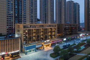 Un hotel moderno con fachada de vidrio, situado en una zona urbana de rascacielos.