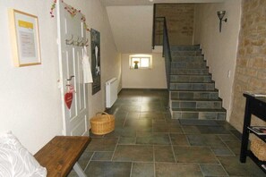 A staircase with stone steps leading to a landing, a basket on the floor, and a wall-mounted light fixture. - Holiday apartment with 2 bedrooms (Holsthum)