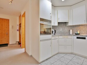 A kitchen with white cabinets, a microwave, and a dishwasher. - Auf der Matta C22 Appartement/Fewo, Dusche oder Bad, WC 3-Zimmerwohnung by Interhome (Davos)