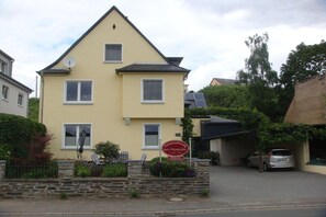 Ein zweistöckiges Wohnhaus mit einem Schild, das es als Pension kennzeichnet.