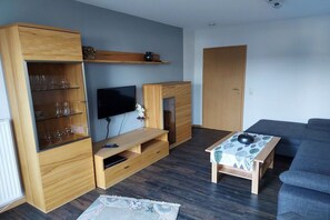 A living room with a TV, wooden furniture, a sofa, and a coffee table. - Holiday apartment in Plein with barbecue (Plein)