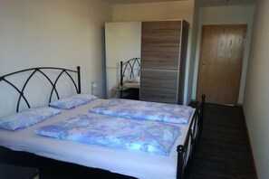 A bedroom with a bed, a wardrobe, and a door. - Holiday apartment in Plein with barbecue (Plein)