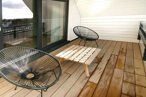 A wooden deck with two black wire chairs and a wooden table. - Beach Residence A305 (Cadzand)