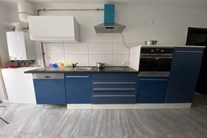 A kitchen with a built-in oven, a sink, and a stove. - Rumble in the Jungle (Oestrich-Winkel)