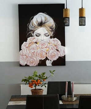 A dining area with a table set for two, a vase with flowers, and a painting on the wall. - Rumble in the Jungle (Oestrich-Winkel)